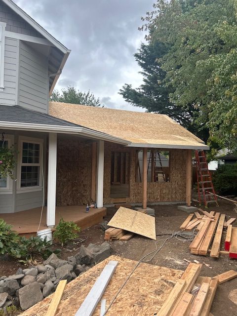 Houses under construction on a sunny day; wooden beams and building materials in the foreground.