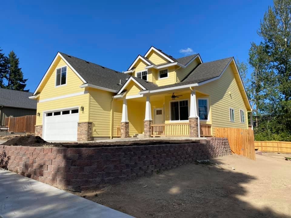 Spacious, light-filled living and dining room with a modern, minimalist design. Neutral colors, wooden floors, and large windows overlooking greenery.