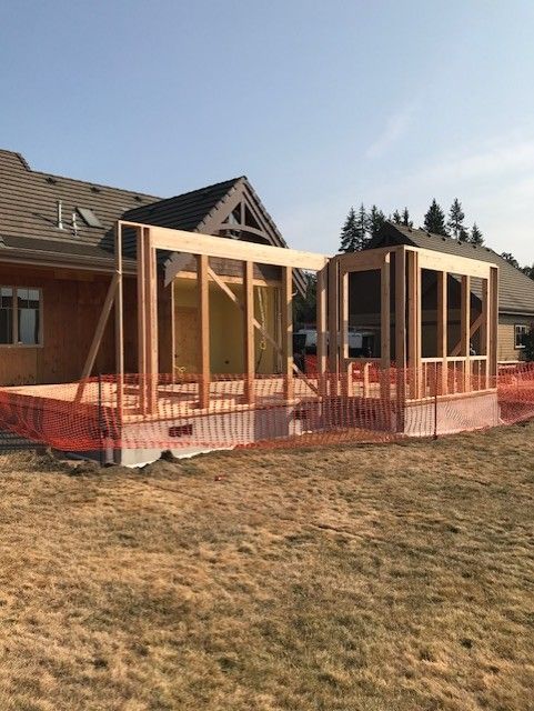 Room under renovation with exposed beams, drywall debris, and open doorways.