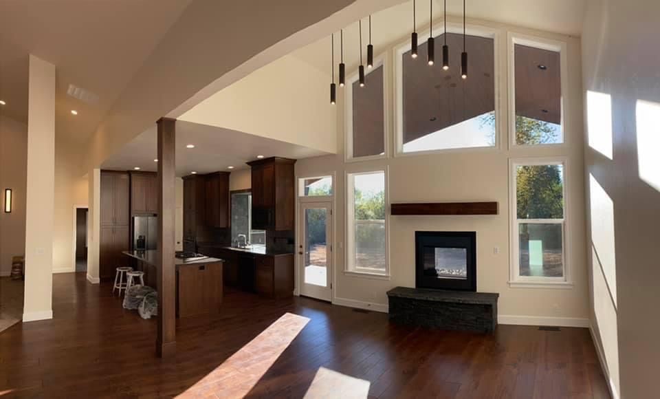 New houses under construction with concrete driveways and blue sky.