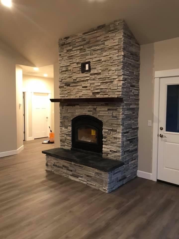 A person's hands examining material samples (wood, stone) on a desk with color swatches, pens, and a ruler.