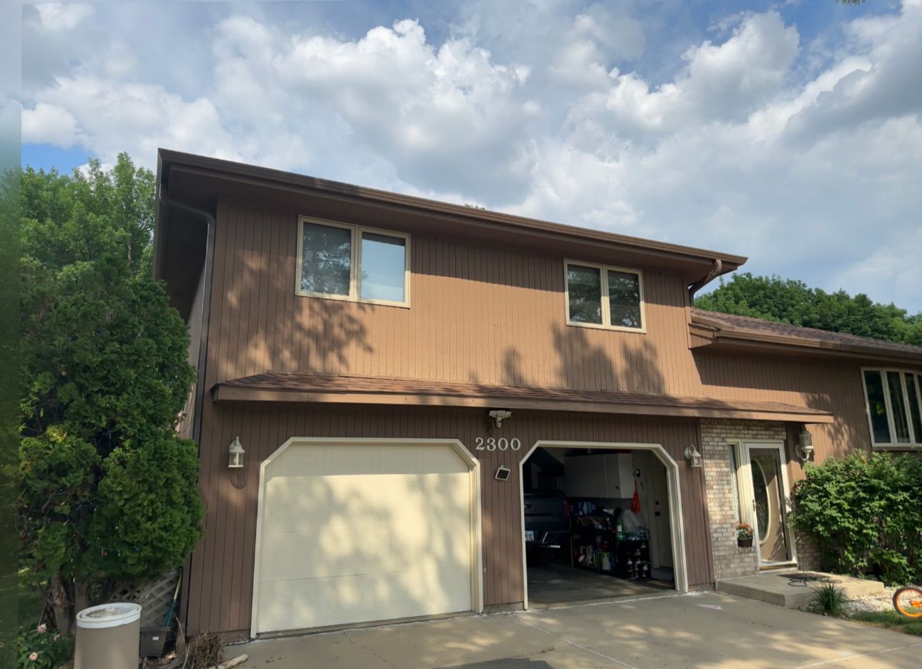 A house with a garage and a car parked in front of it.