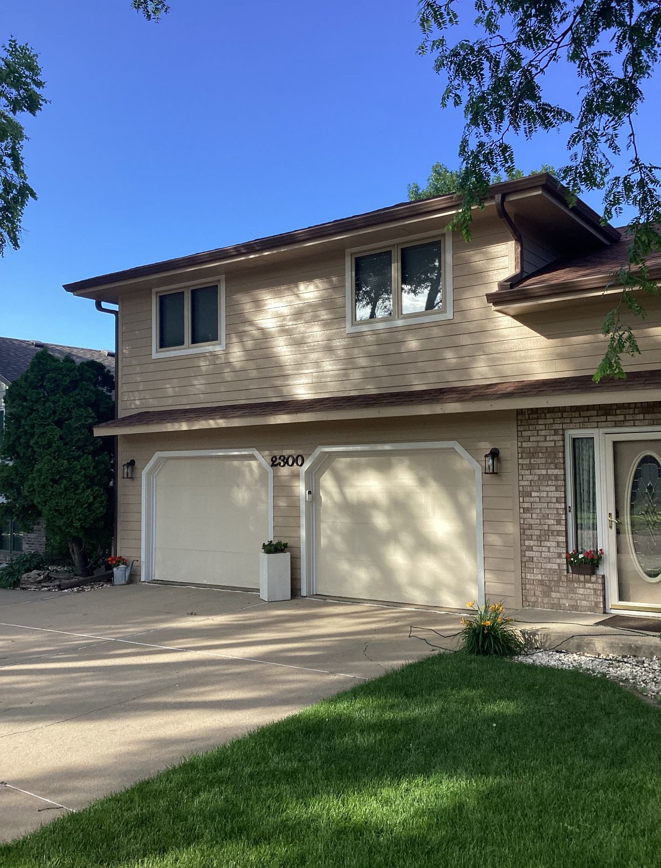 A house with three garage doors and a blue sky in the background