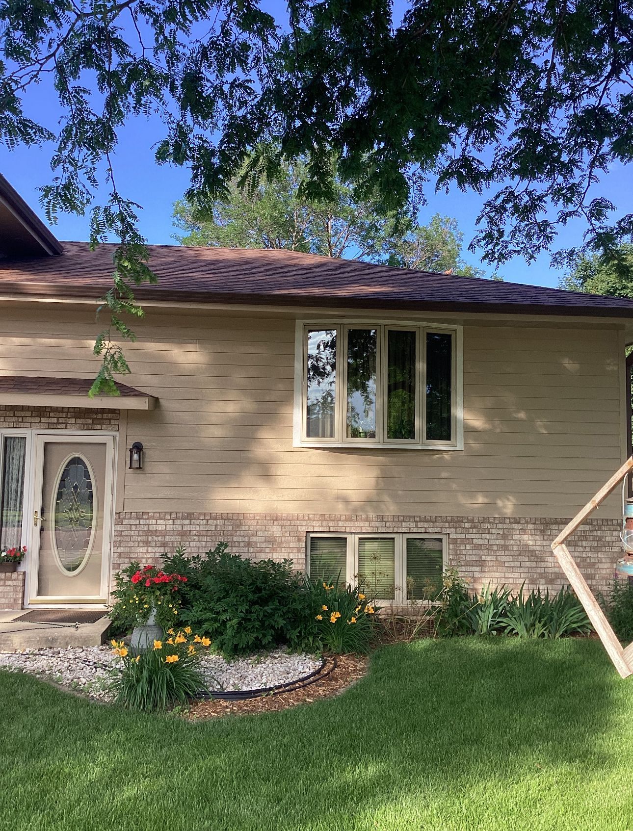 A house with a lot of windows and flowers in front of it.