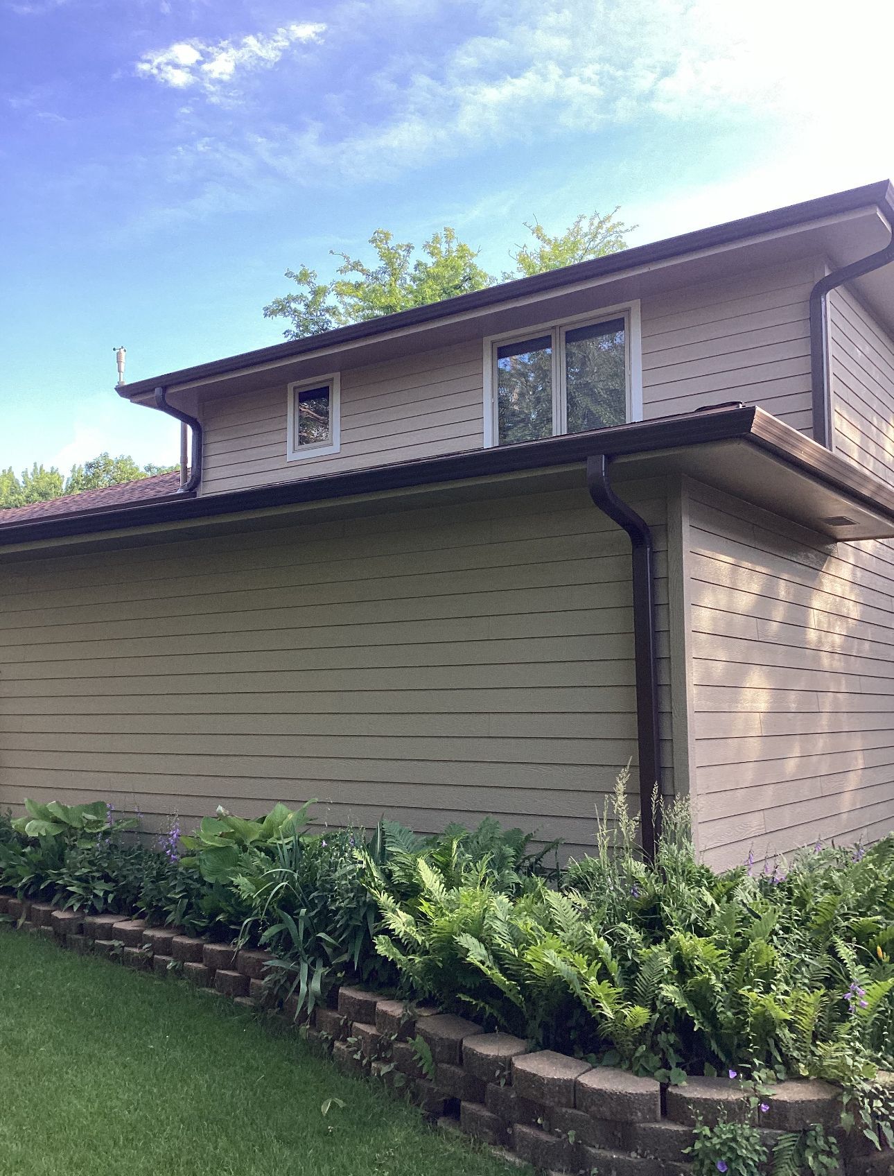 A house with a lot of windows and a gutter on the side of it.