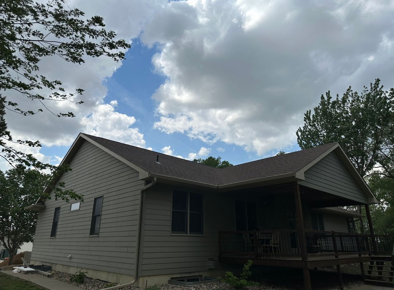 a house with a porch and a blue sky in the background