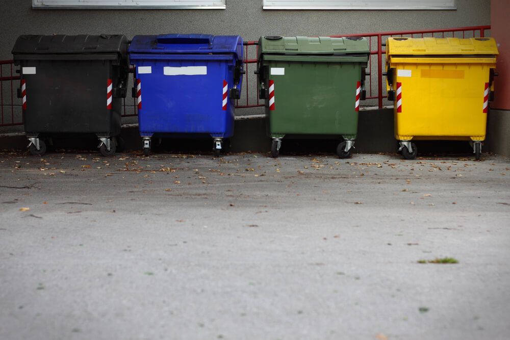 A Row of Garbage Cans Are Lined Up in Front of a Building — Swift Skips in Gympie, QLD