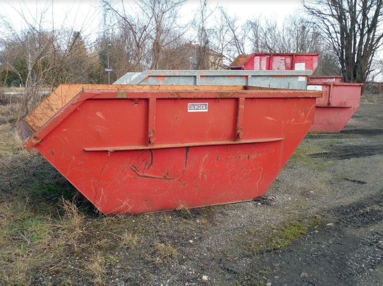 A red Skip Bin in Dirt Field — Swift Skips in Gympie, QLD