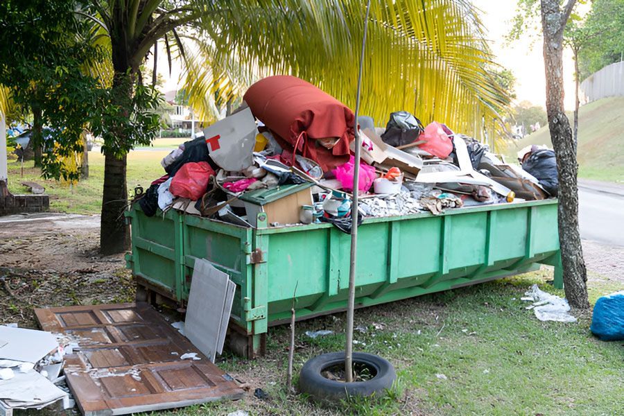 A Green Dumpster Filled With Trash in a Park — Swift Skips in Gympie, QLD