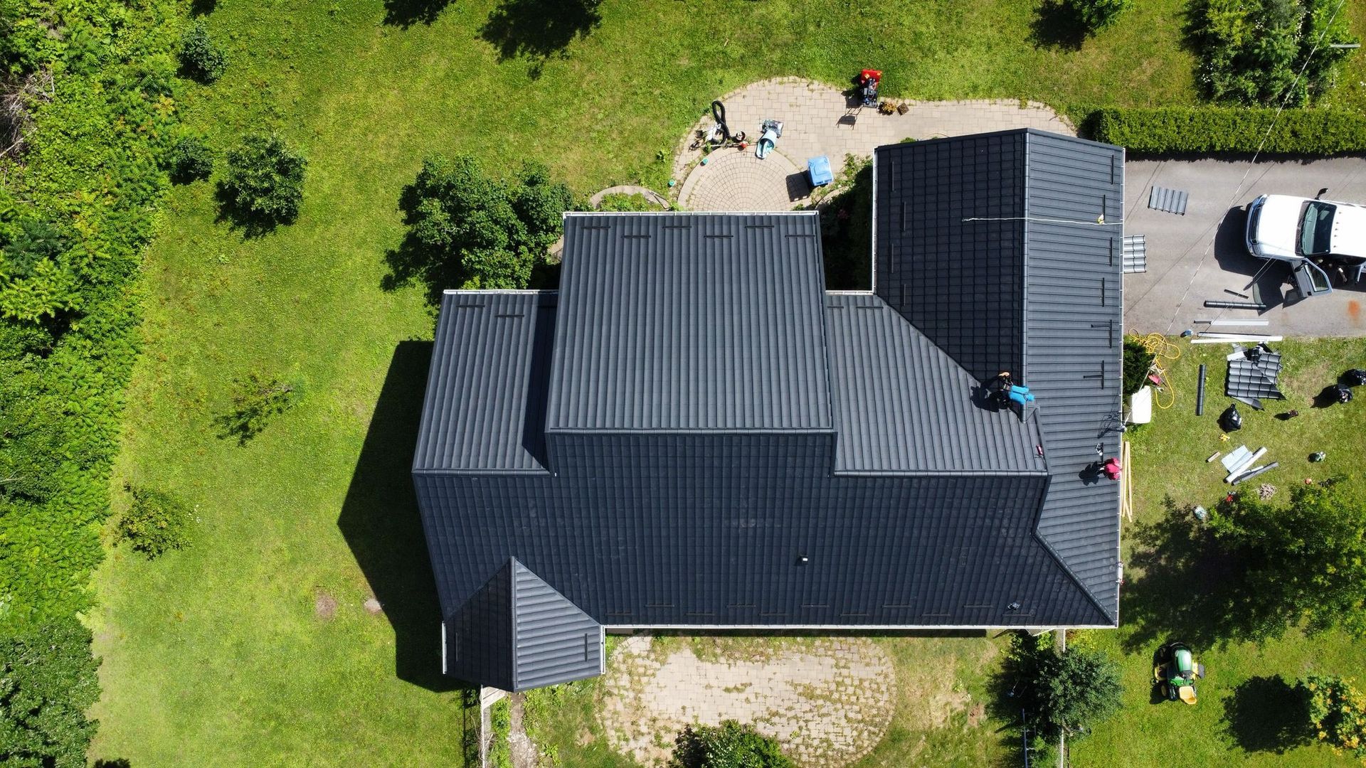 Une vue aérienne d'une maison avec un toit noir en cours d'installation.