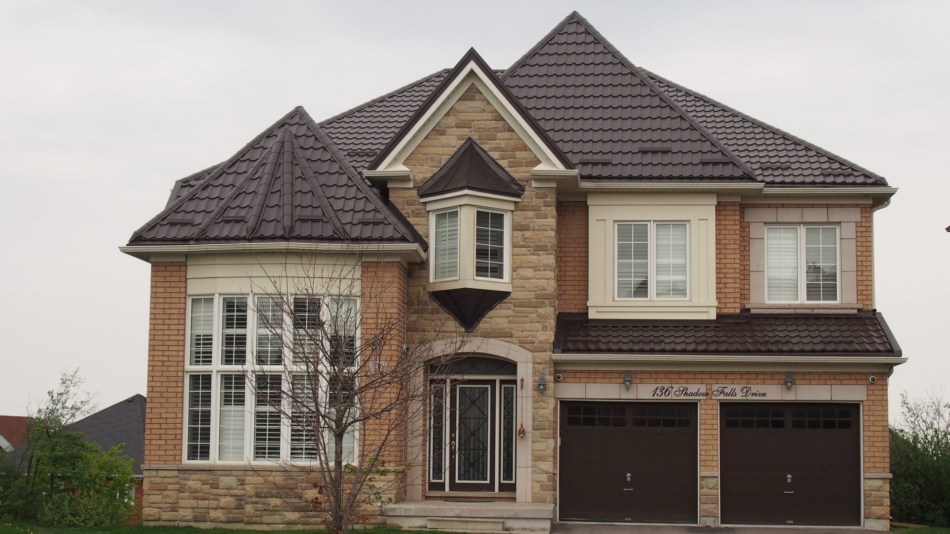 Une grande maison en briques avec un toit brun