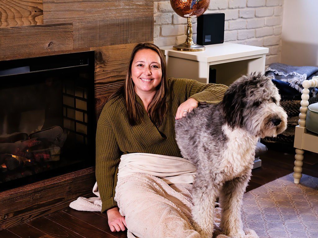 Jess holding her dog in front of the fire place