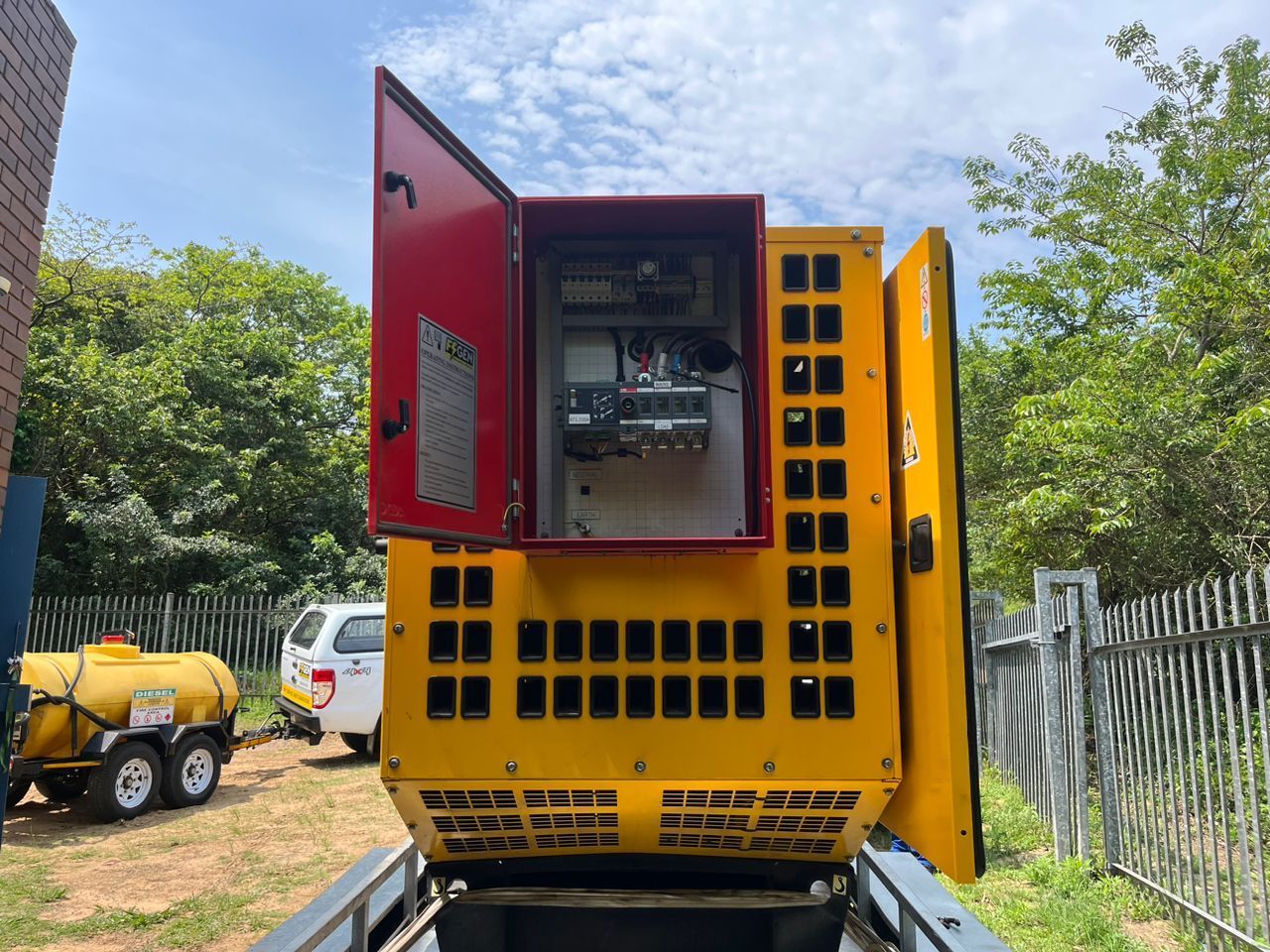 The back of a yellow truck with the door open.