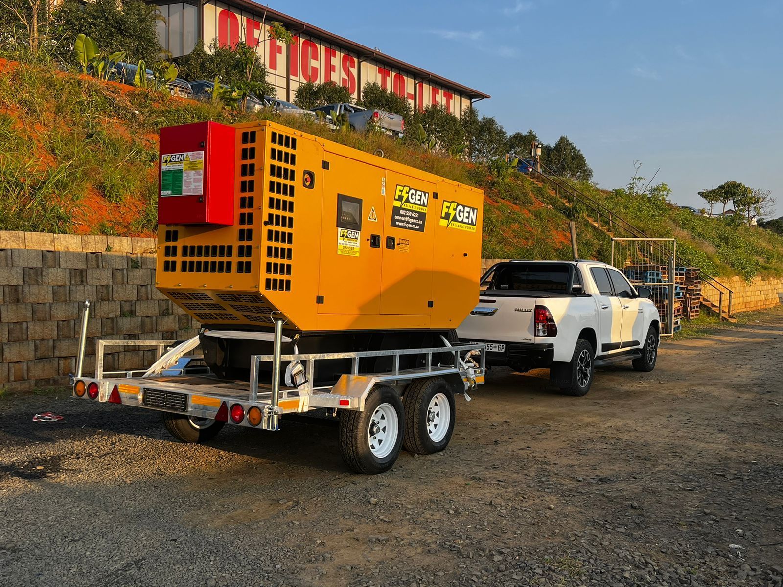 A truck is towing a generator on a trailer.