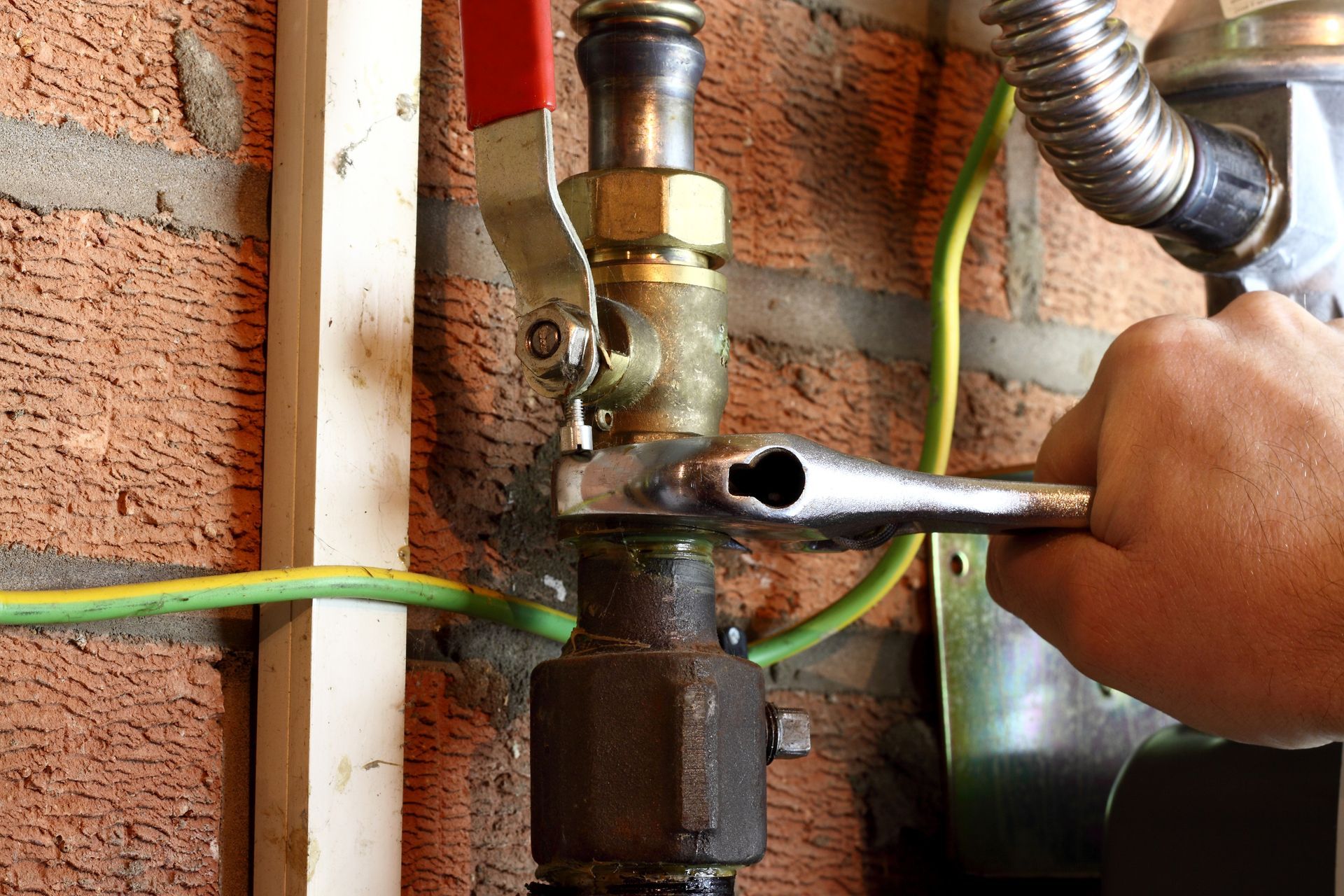 Engineer carefully connecting a copper gas pipe in a residential setting.