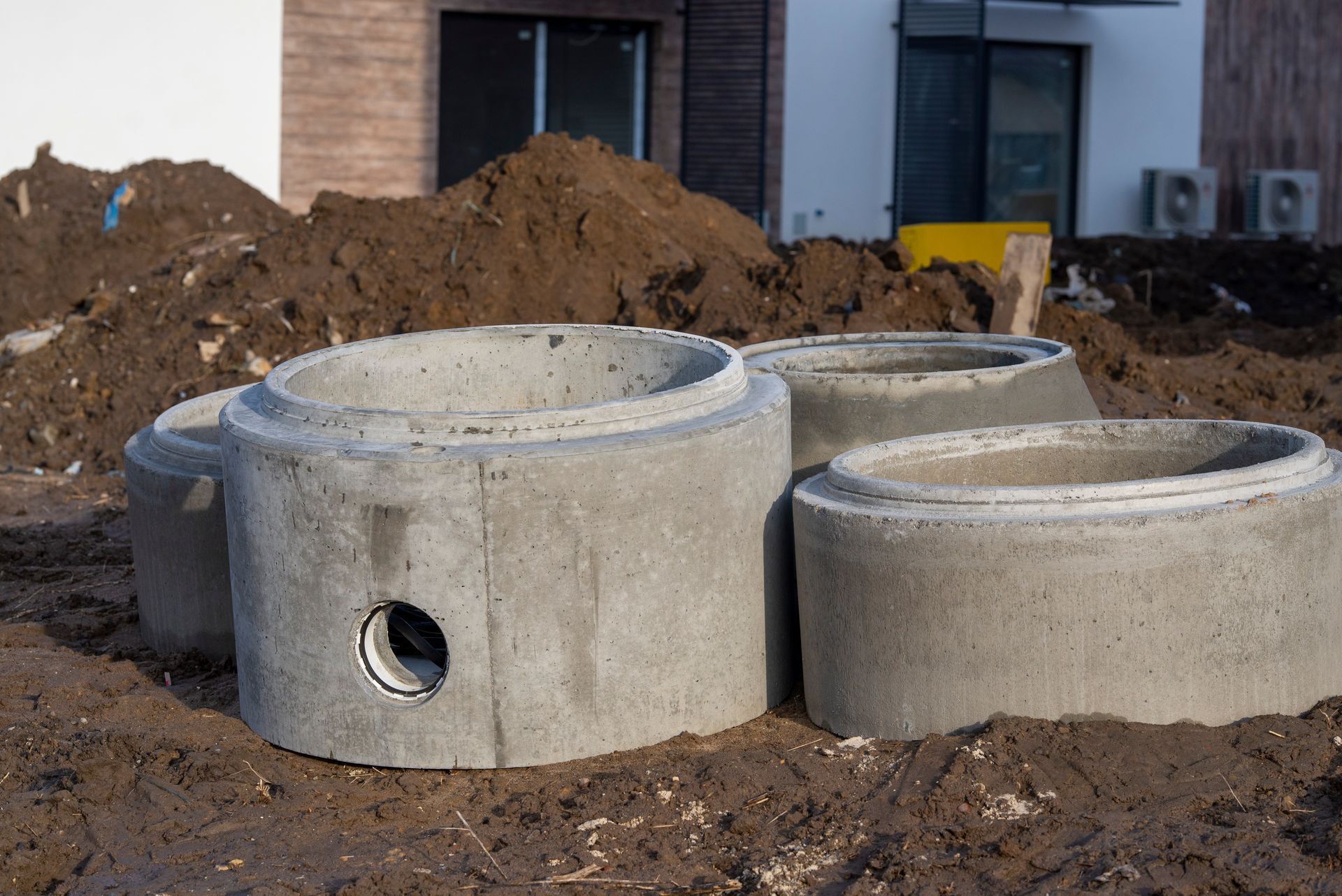Concrete drainage pipe in a construction site, part of a stacked sewage water system.