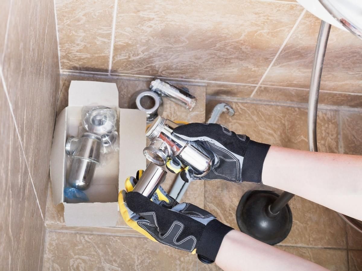 a person is fixing a shower head in a bathroom .