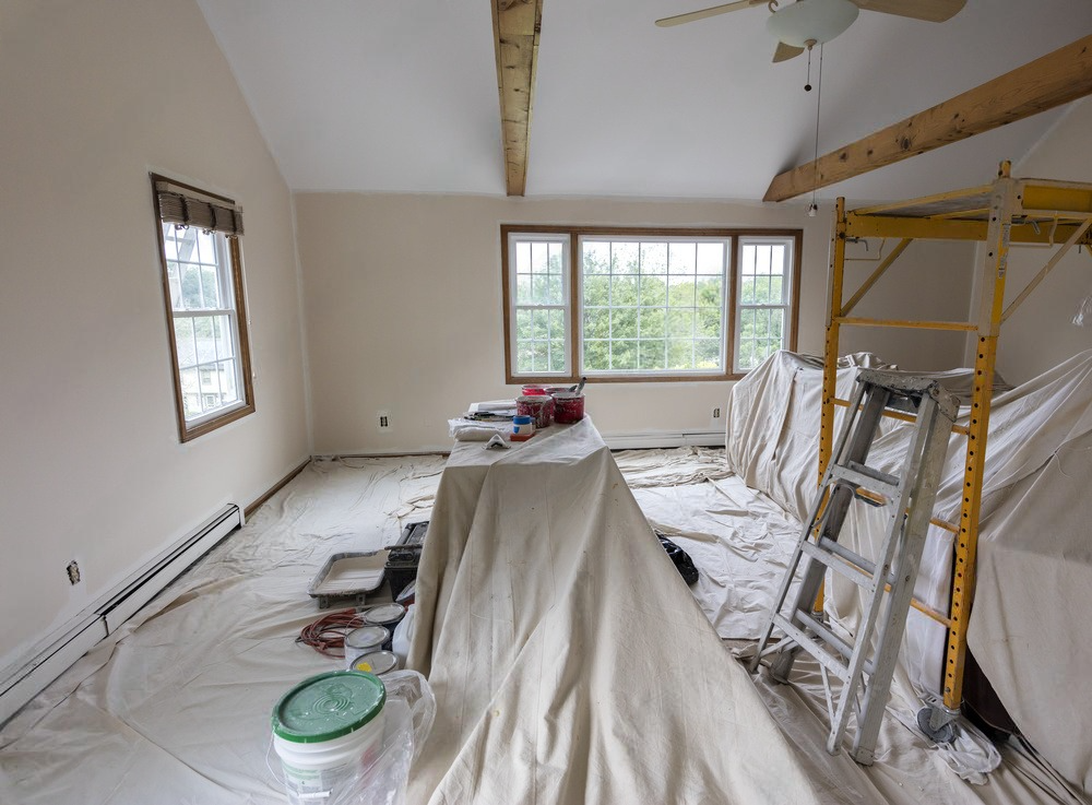 a room that is being painted with a ladder and buckets of paint