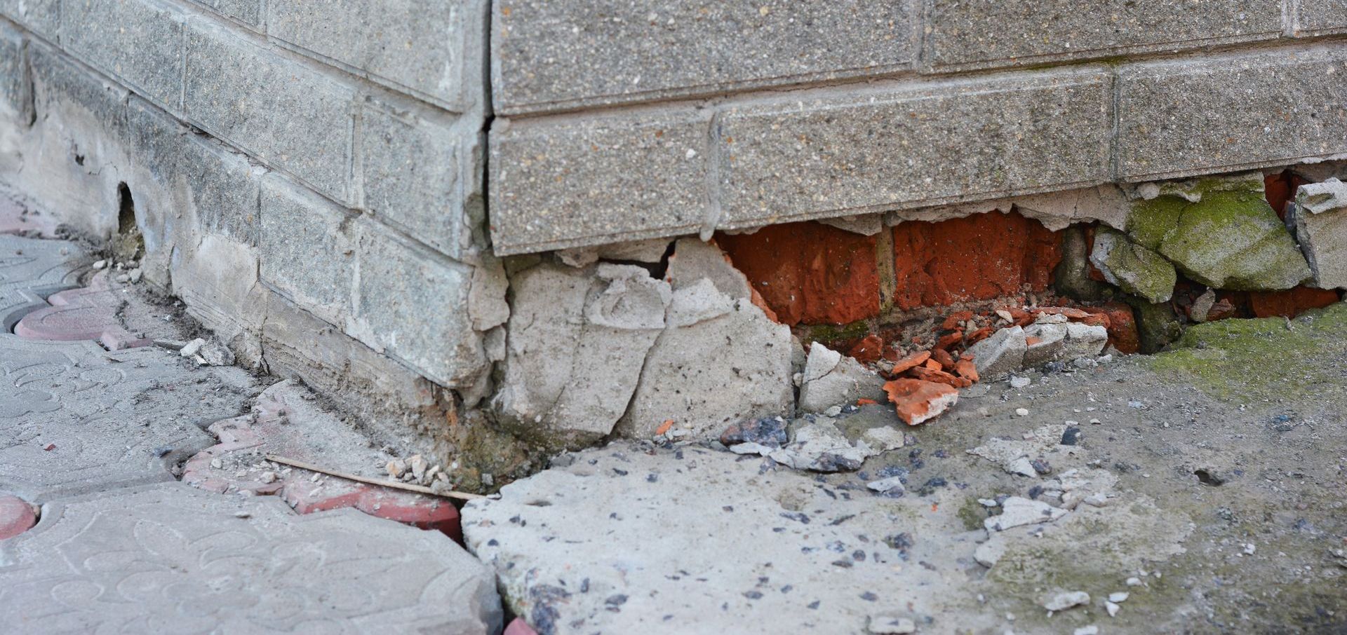 A close up of a brick wall with cracks in it.