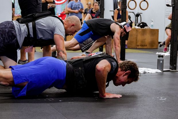 A group of men are doing push ups in a gym.