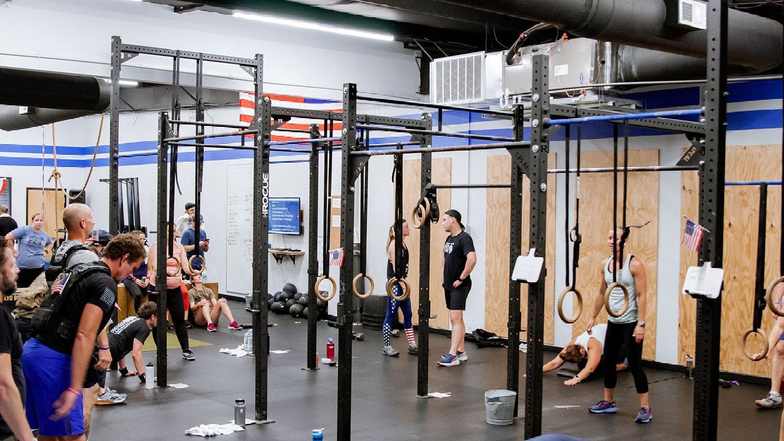 A group of people are doing crossfit exercises in a gym.