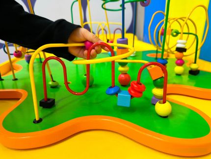 A person is playing with a colorful toy on a table.