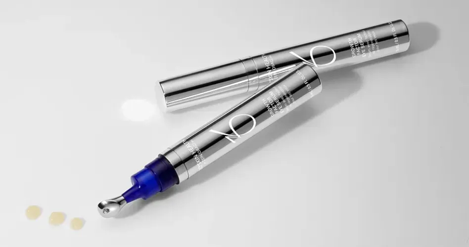 Silver Zo eye cream applicator with open lid and three small dots of product.