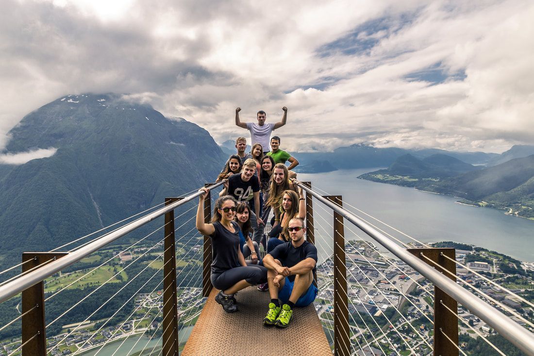 A group of people are posing for a picture on top of a mountain.