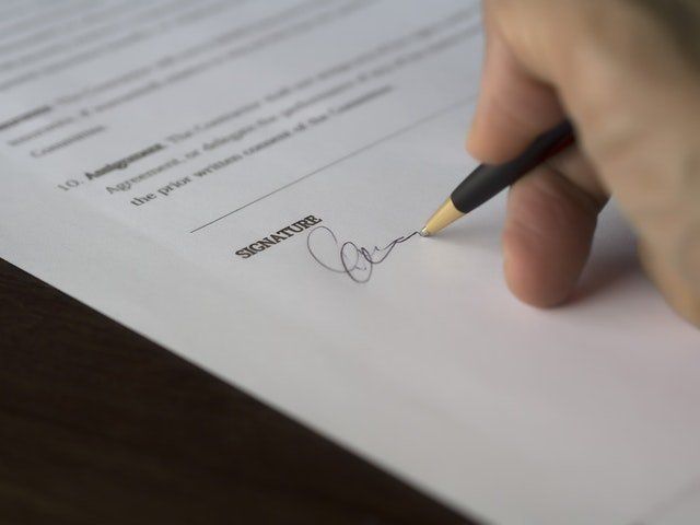 man signing a contract of some sort