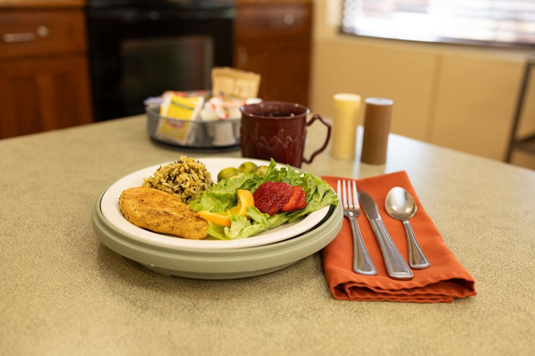 A plate of food is sitting on a table with utensils.