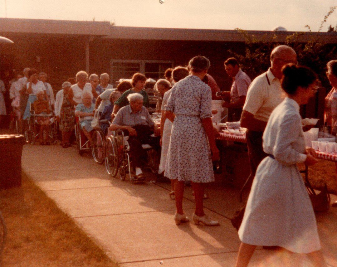 A group of people are gathered outside of a building