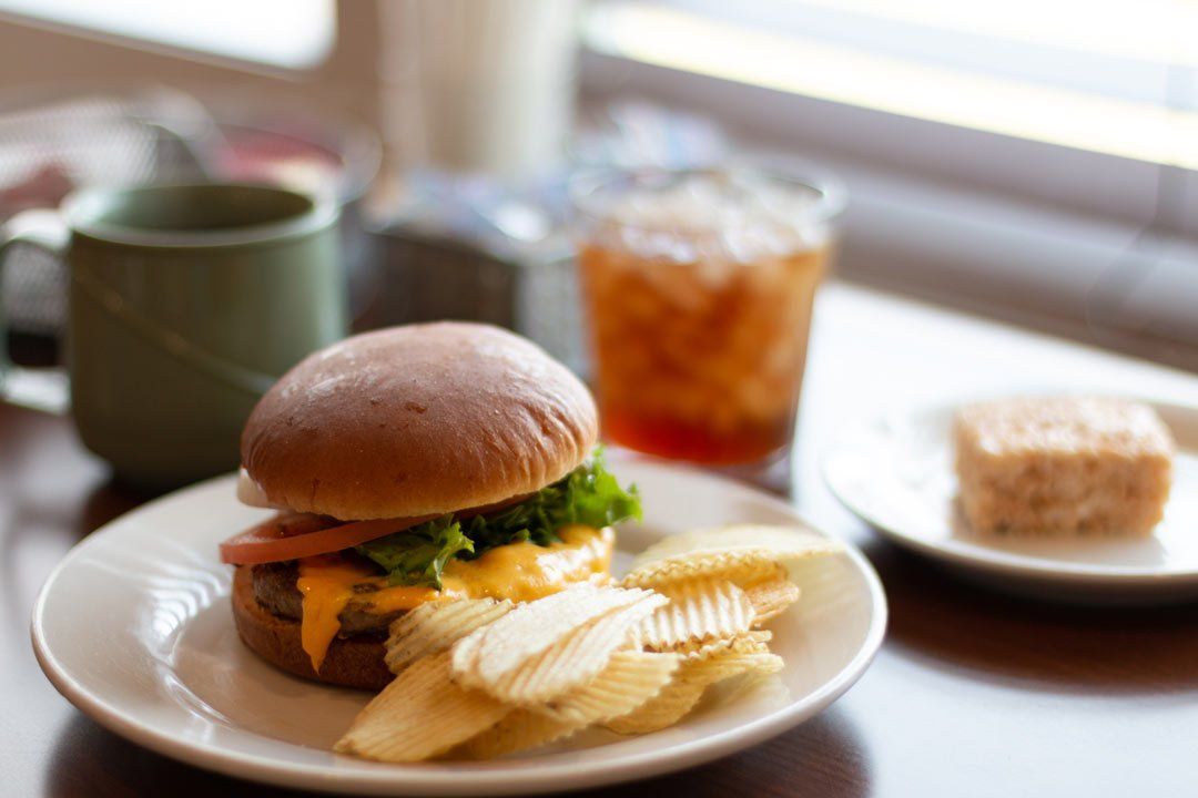 A white plate topped with a hamburger and potato chips