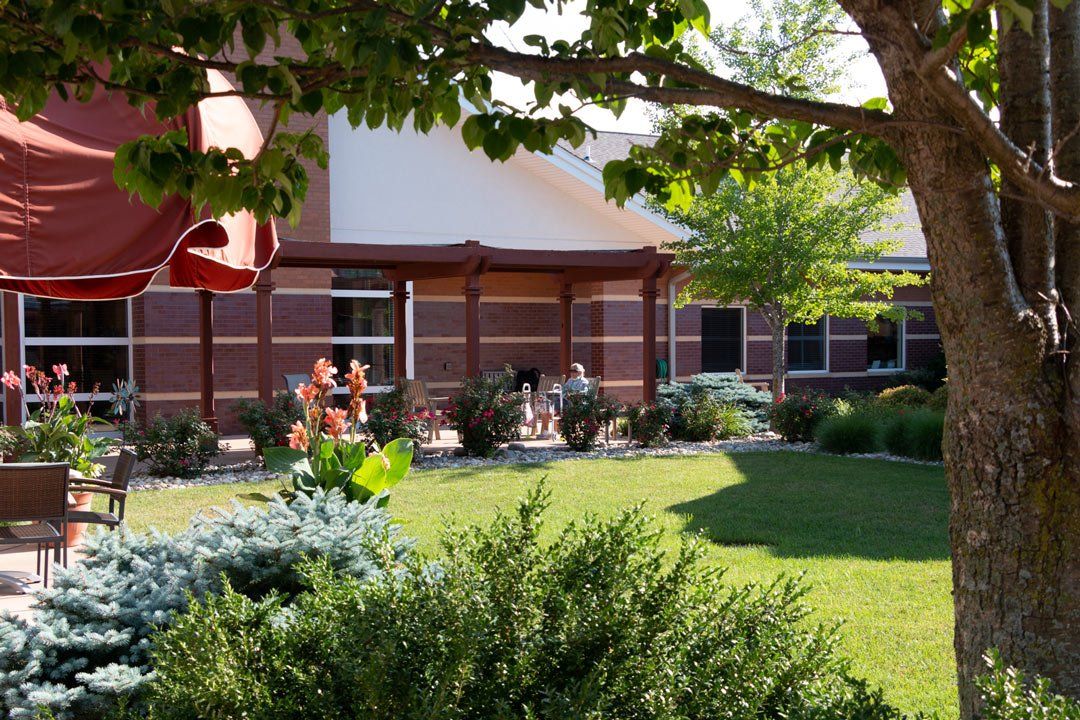 A house with a large lawn and a tree in front of it