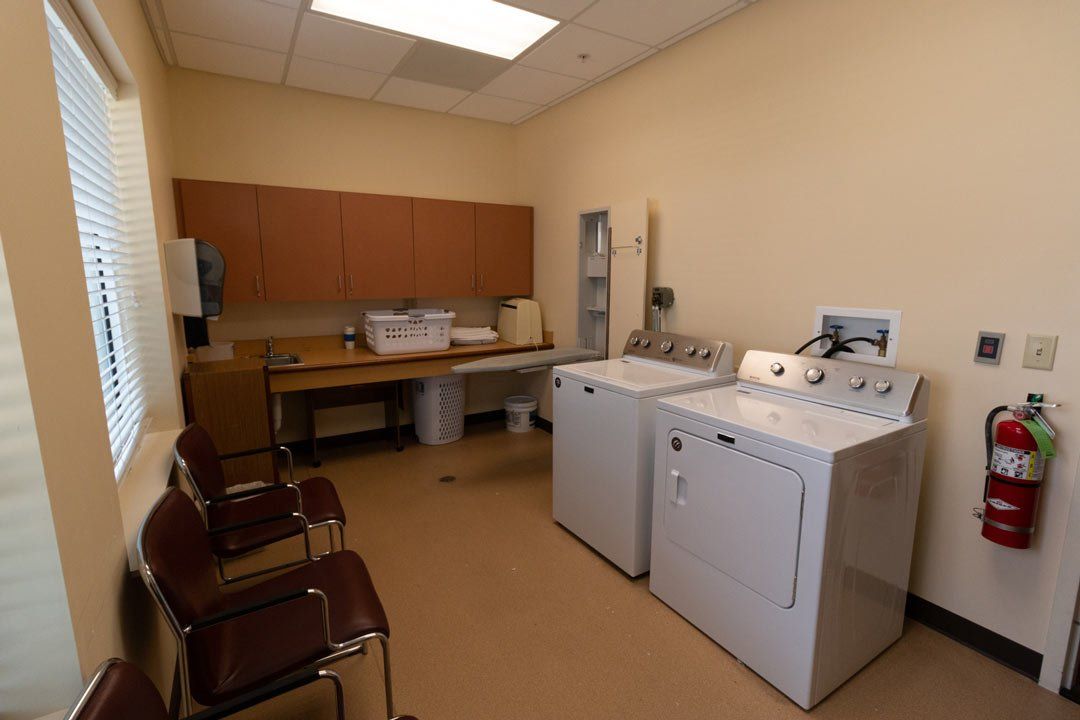 A laundry room with a washer and dryer and a fire extinguisher