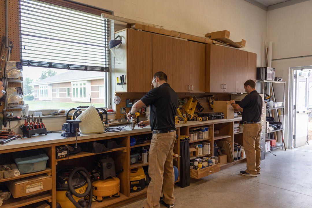 Two men are working on a project in a workshop.