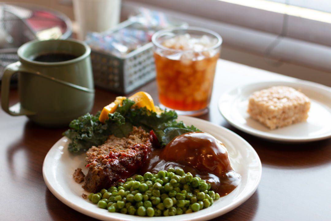 A plate of food on a table with a cup of coffee