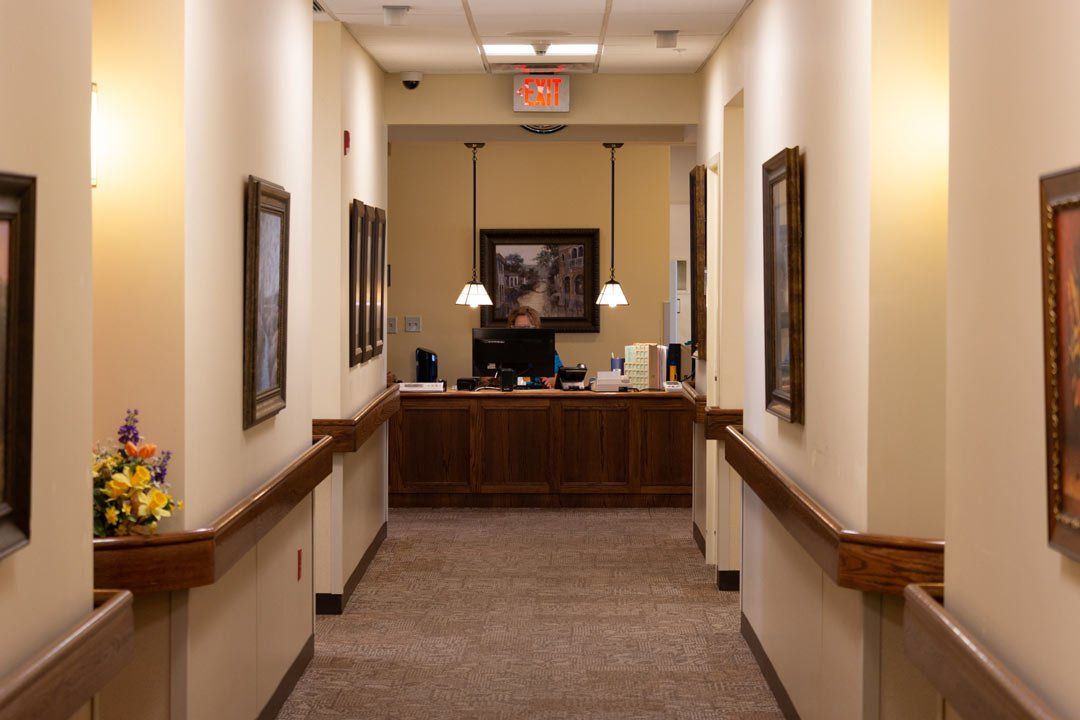 A long hallway leading to a reception desk in a hospital.