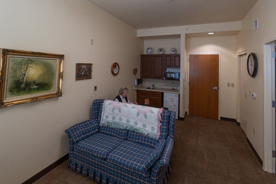 A man is sitting on a couch in a living room.