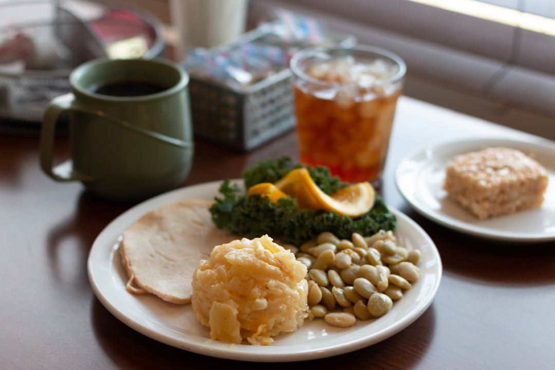 A plate of food on a table with a cup of coffee