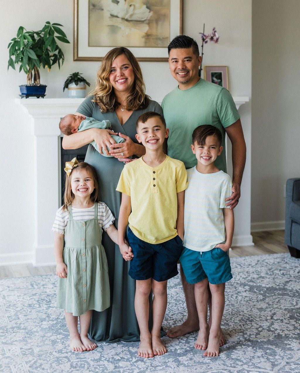 The Truong family is posing for a picture in a living room.