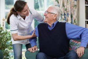 Care Worker Helping Senior Man to Get Up - Home Health Aide in Joliet, IL