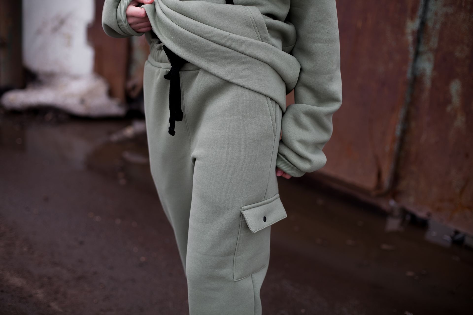 A person in a sage green sweatsuit
