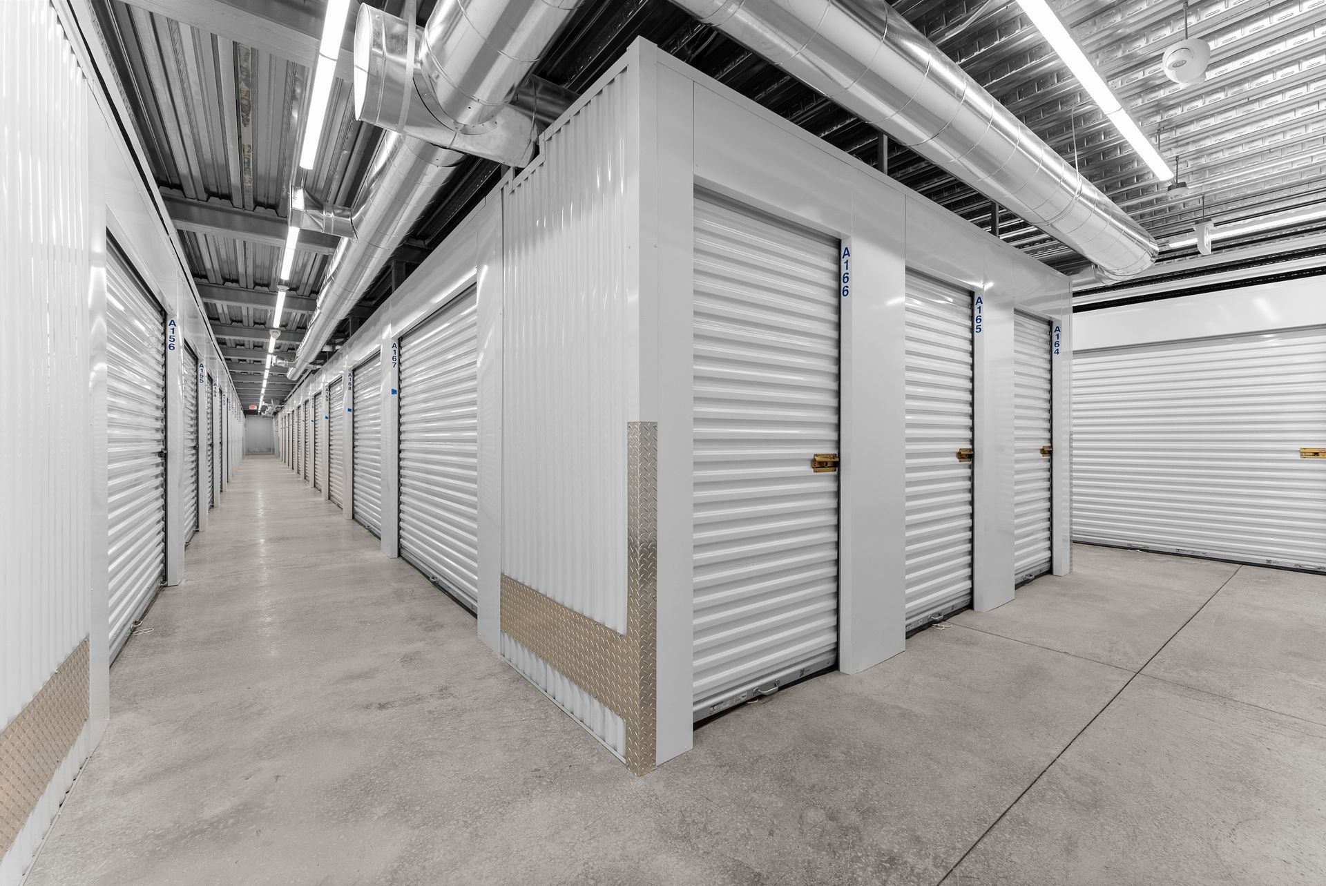 A black and white photo of a storage room with a door open.