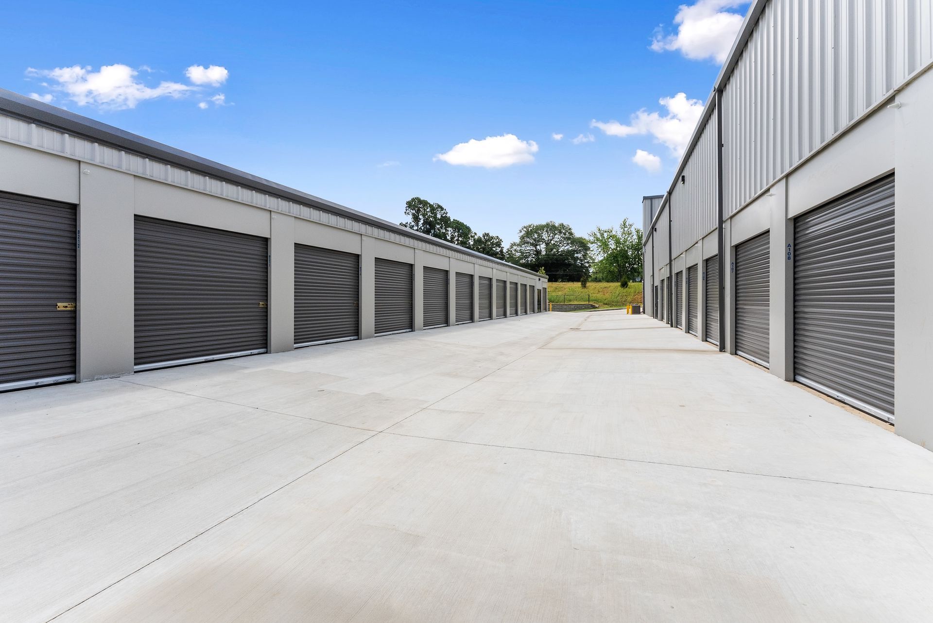 A black and white photo of a long hallway filled with lots of lockers.