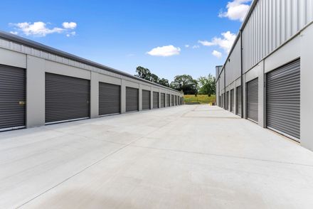 A black and white photo of a long hallway filled with lots of lockers.