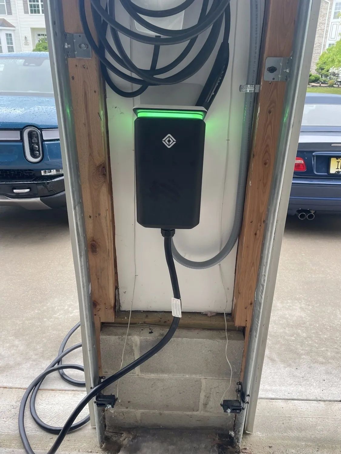 A car is being charged at a charging station in a garage.