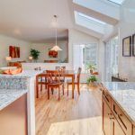 A kitchen with a table and chairs and a skylight in the ceiling.