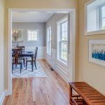 A hallway leading to a dining room with a table and chairs.