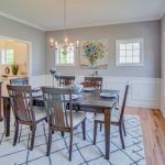 A dining room with a table and chairs and a rug.