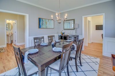 A dining room with a table and chairs and a chandelier.